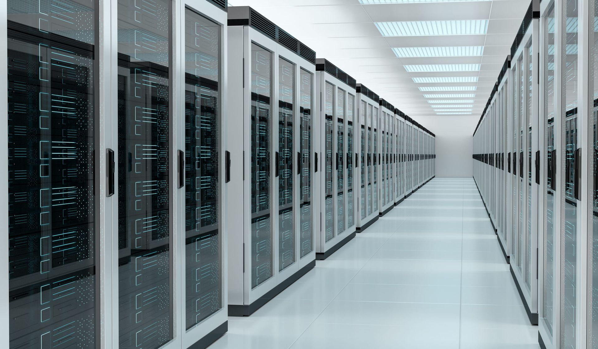 A long data-centre aisle between two rows of black server racks under a lit white ceiling
