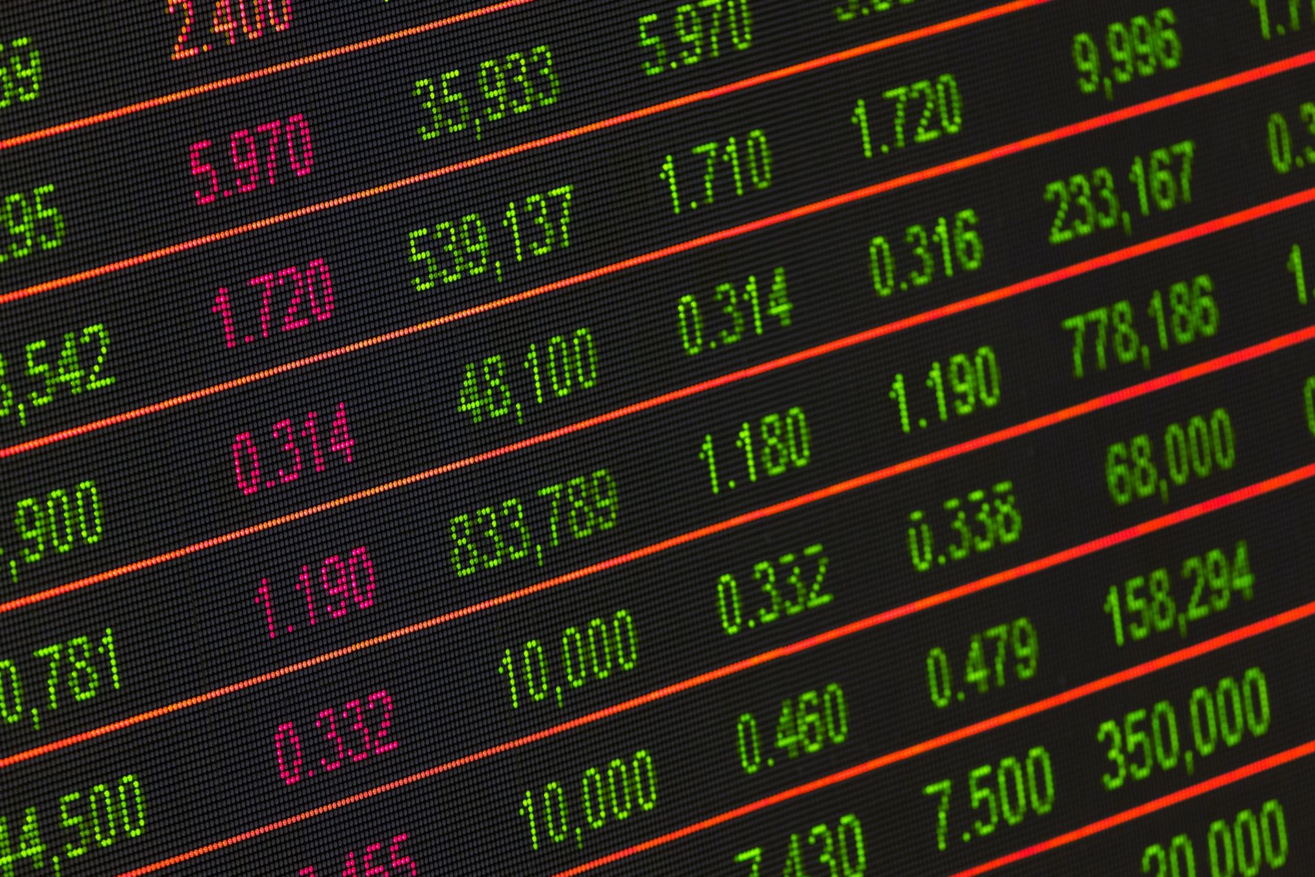 Rows of green and magenta prices beside six-figure volumes on an angled market quote board.